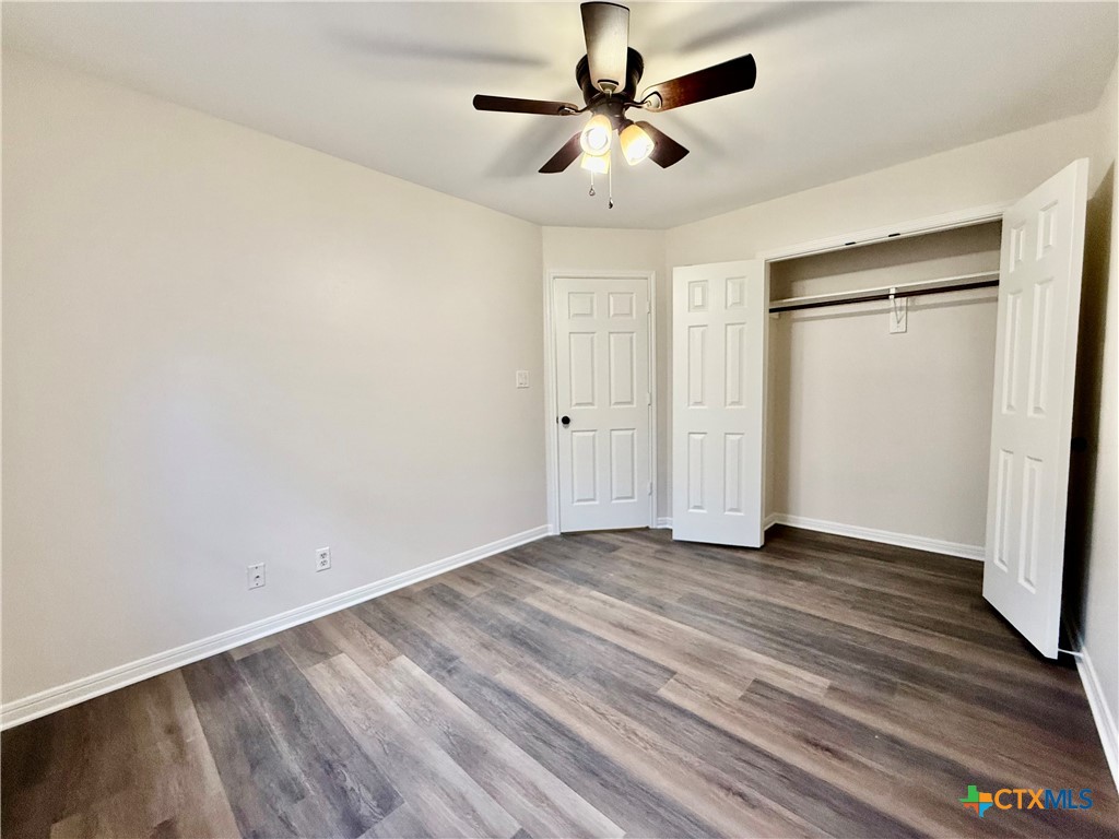 210 Stone Gate Drive Victoria, TX 77904 - Photo 13 of 23 an empty room with wooden floor and windows