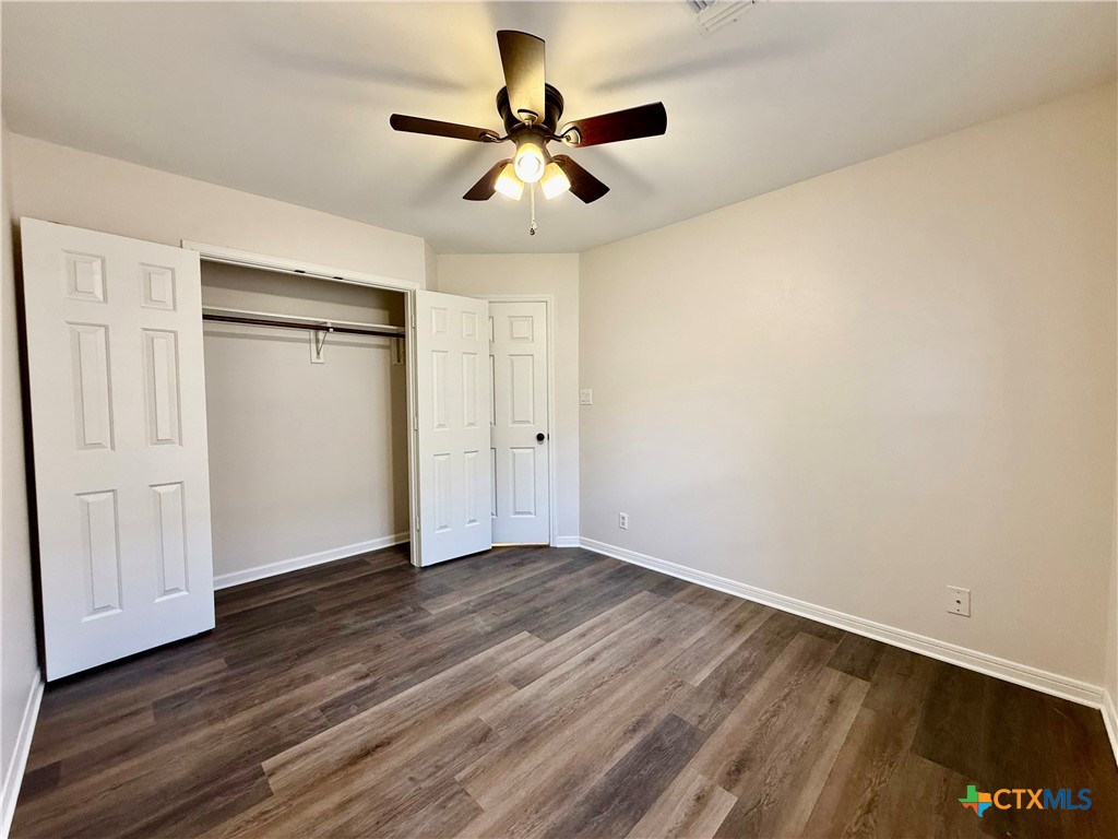 210 Stone Gate Drive Victoria, TX 77904 - Photo 15 of 23 an empty room with wooden floor ceiling fan and windows