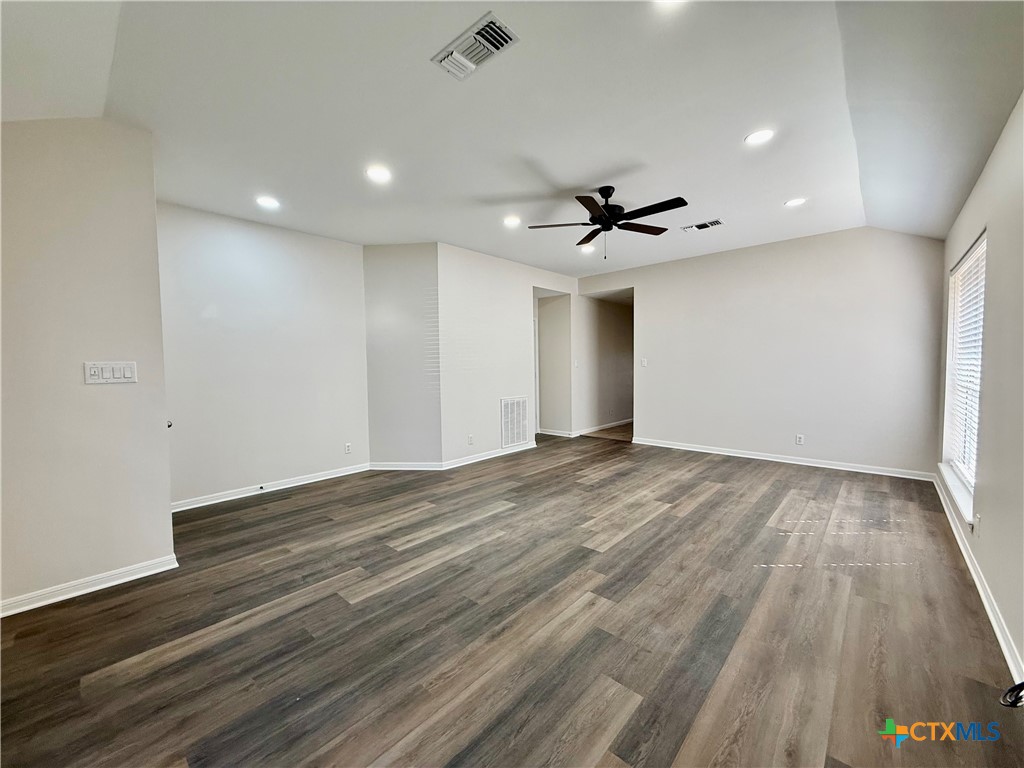 210 Stone Gate Drive Victoria, TX 77904 - Photo 5 of 23 a view of an empty room with wooden floor and a ceiling fan