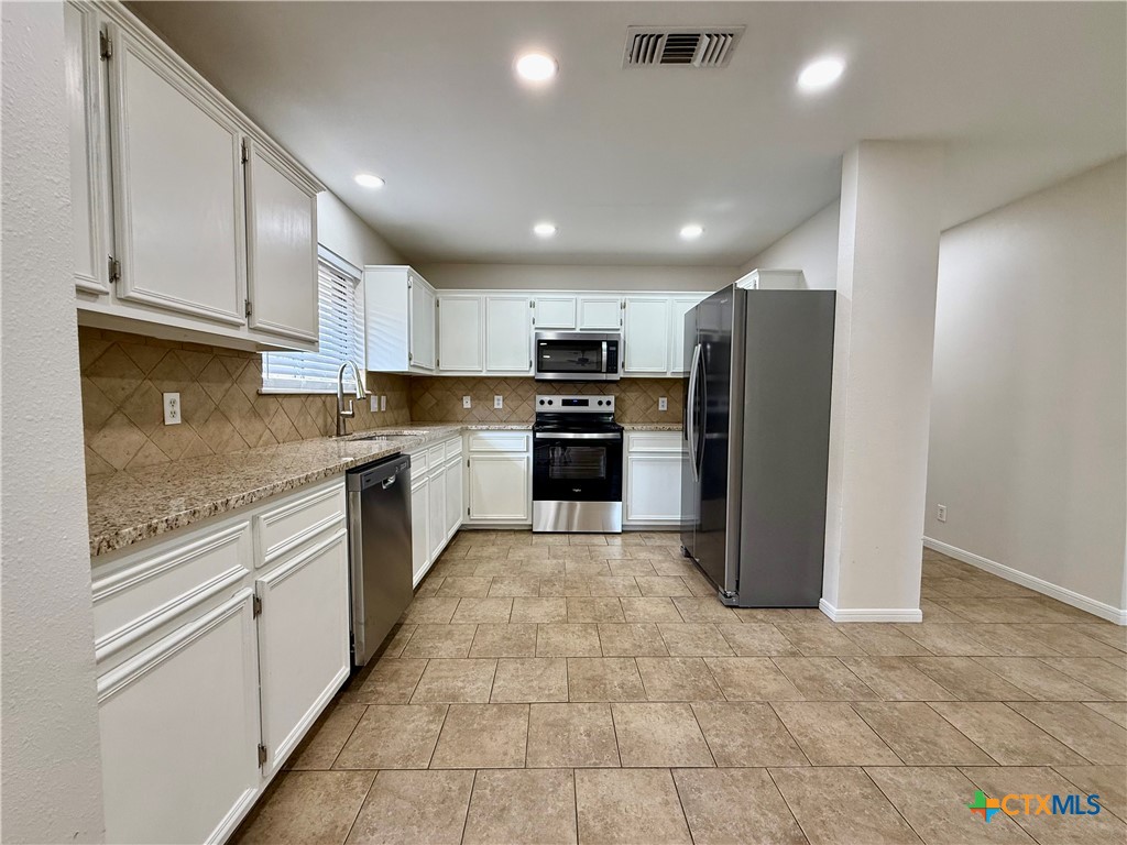 210 Stone Gate Drive Victoria, TX 77904 - Photo 6 of 23 a large kitchen with stainless steel appliances granite countertop a refrigerator and a stove top oven