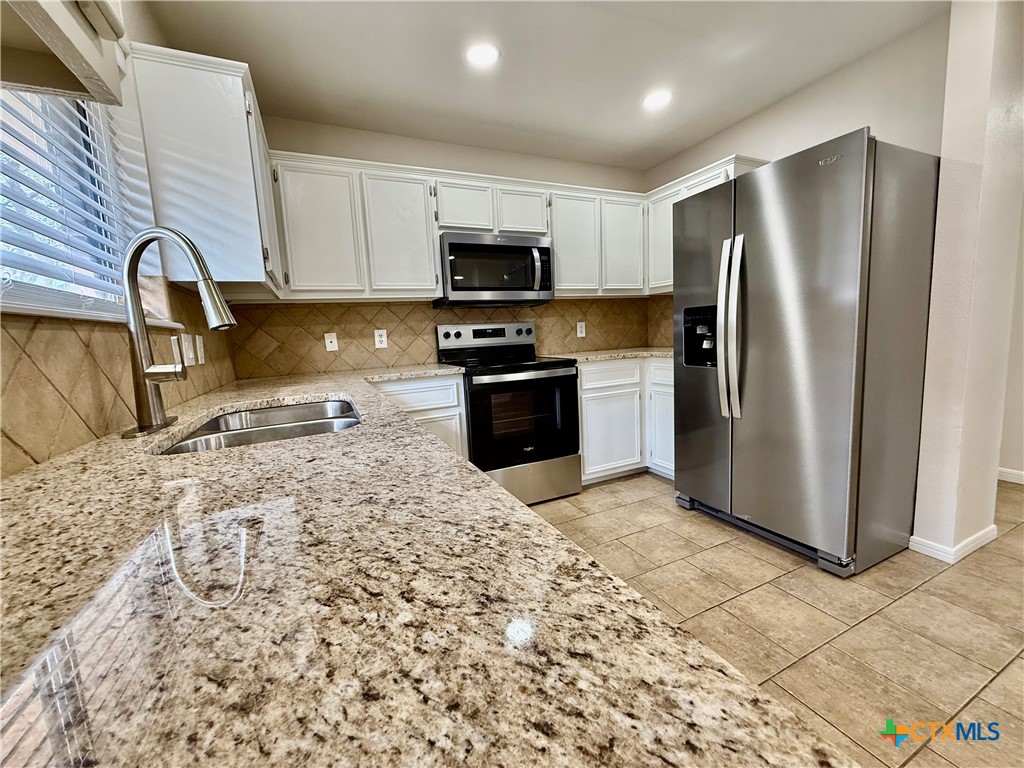 210 Stone Gate Drive Victoria, TX 77904 - Photo 8 of 23 a kitchen with stainless steel appliances granite countertop a refrigerator a stove a sink and a microwave