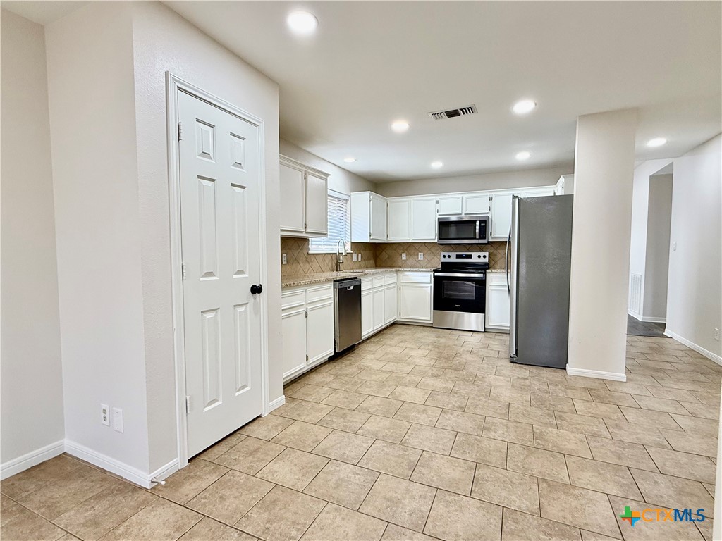 210 Stone Gate Drive Victoria, TX 77904 - Photo 9 of 23 a large kitchen with cabinets and stainless steel appliances