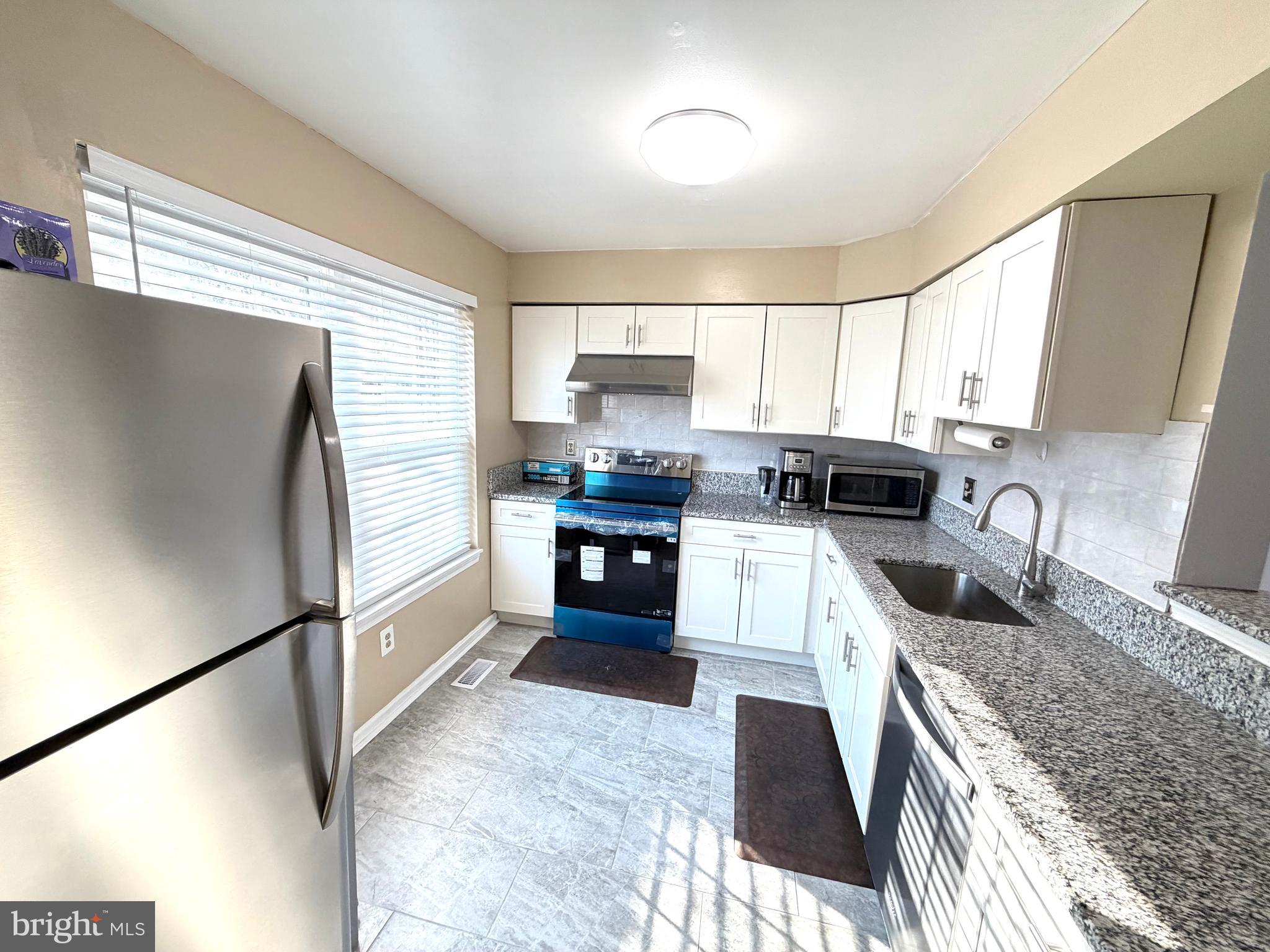 8 Hardwood Drive Rosedale, MD 21237 - Photo 5 of 42 a kitchen with granite countertop a refrigerator and a sink