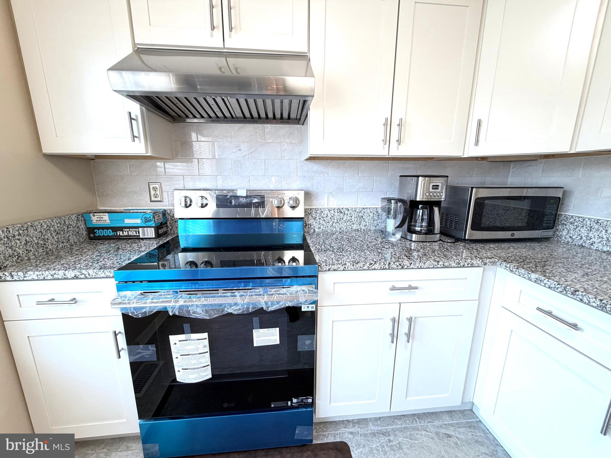 8 Hardwood Drive Rosedale, MD 21237 - Photo 6 of 42 a kitchen with stainless steel appliances granite countertop a stove a sink and a microwave