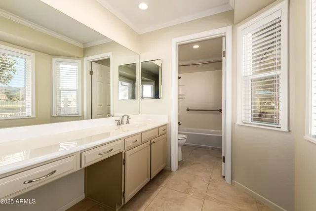 a bathroom with a granite countertop sink mirror and a bathtub
