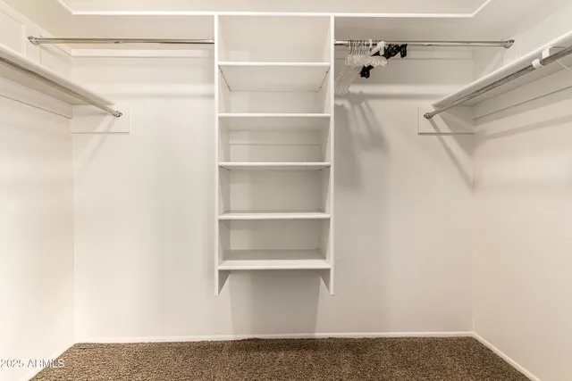 a view of walk in closet with empty racks