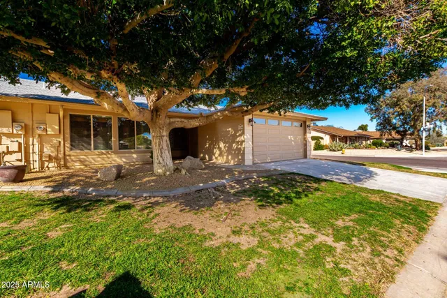 a front view of a house with a yard and trees