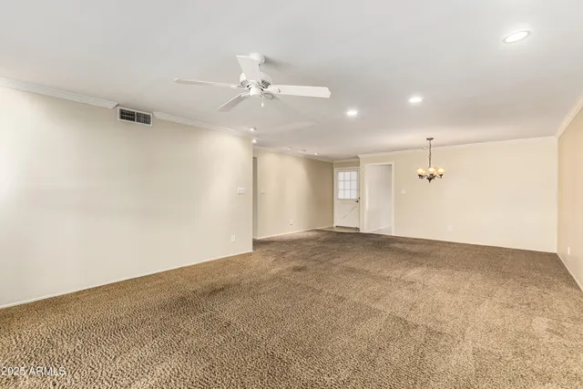 an empty room with an entryway and fan