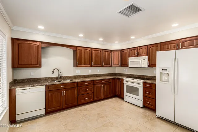 a large kitchen with stainless steel appliances granite countertop a stove sink and cabinets