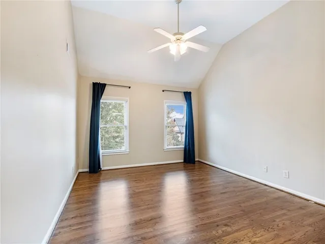 a view of an empty room with a window and a kitchen