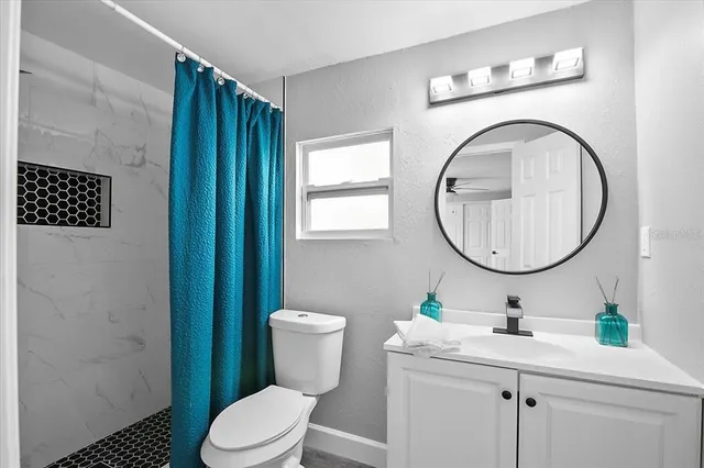 a bathroom with a toilet a sink a mirror and a shower