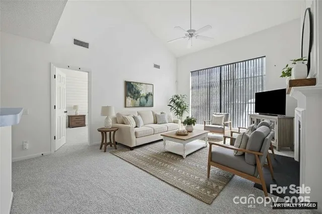 a living room with furniture a flat screen tv and a large window
