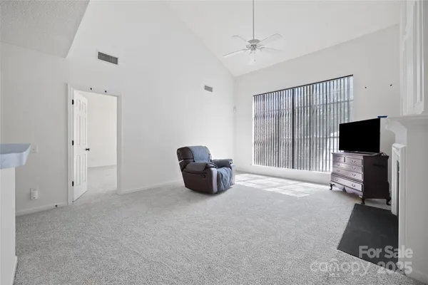 a living room with furniture a flat screen tv and a large window