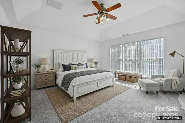 a spacious bedroom with a bed a couch and a window