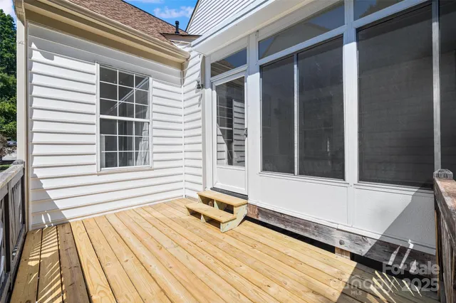 a view of a balcony with a large window and wooden floor
