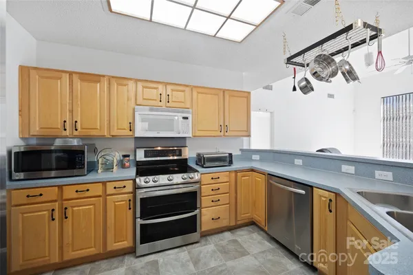 a kitchen with granite countertop a sink stainless steel appliances and cabinets