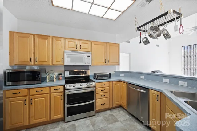 a kitchen with granite countertop a sink stainless steel appliances and cabinets