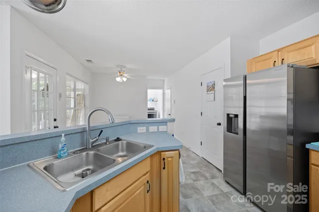 a kitchen with stainless steel appliances granite countertop a sink refrigerator and cabinets