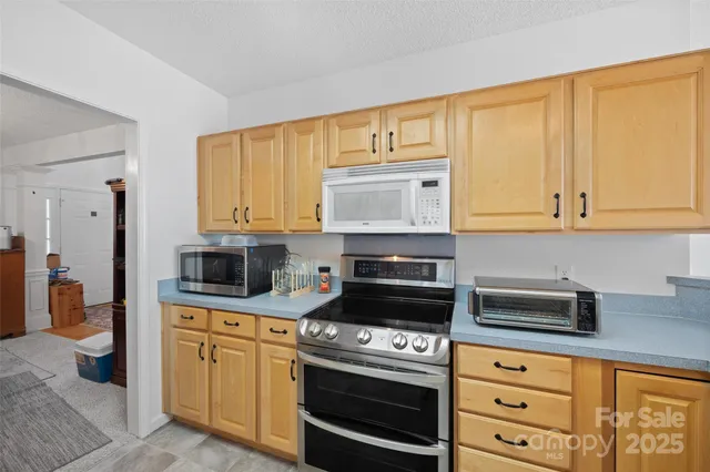 a kitchen with stainless steel appliances granite countertop a stove a sink and a microwave