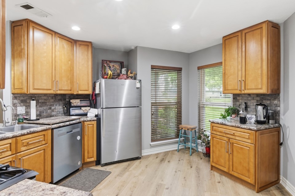 9211 Benwick Street Spring, TX 77379 - Photo 13 of 27 a kitchen with stainless steel appliances granite countertop a refrigerator a sink a stove and white cabinets