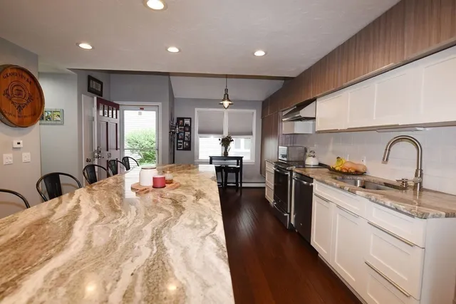 a large kitchen with stainless steel appliances granite countertop a lot of counter space and a sink