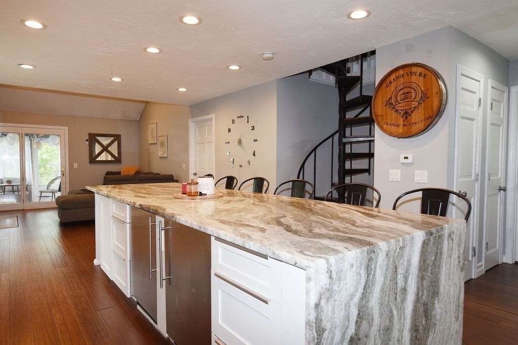1559 Bay Street, Unit 53 Taunton, MA 02780 - Photo 15 of 40 a kitchen with stainless steel appliances granite countertop a sink a stove a refrigerator and a dining table with wooden floor