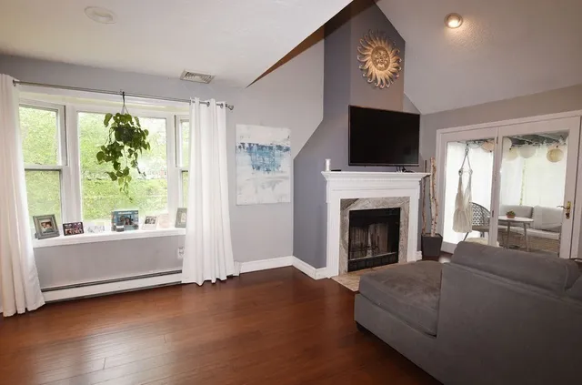 a living room with furniture a fireplace and a flat screen tv
