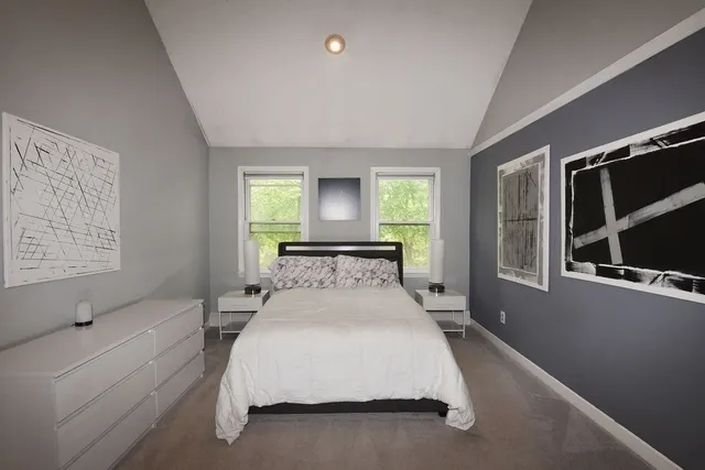 a spacious bedroom with a bed and a large window