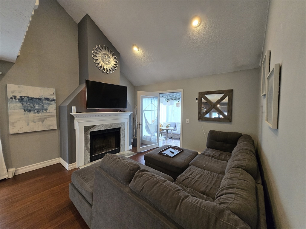 1559 Bay Street, Unit 53 Taunton, MA 02780 - Photo 4 of 40 a living room with furniture a flat screen tv and a fireplace