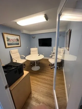 a living room with chairs and a flat screen tv
