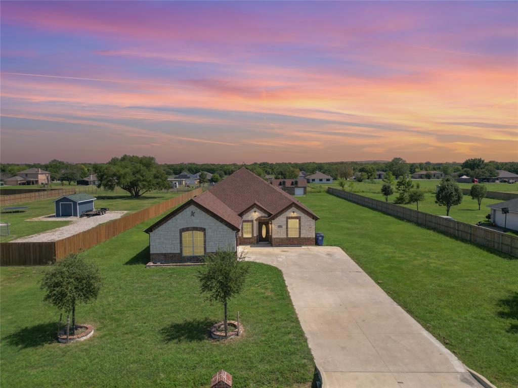 French country home featuring driveway, stone siding, and a rural view
