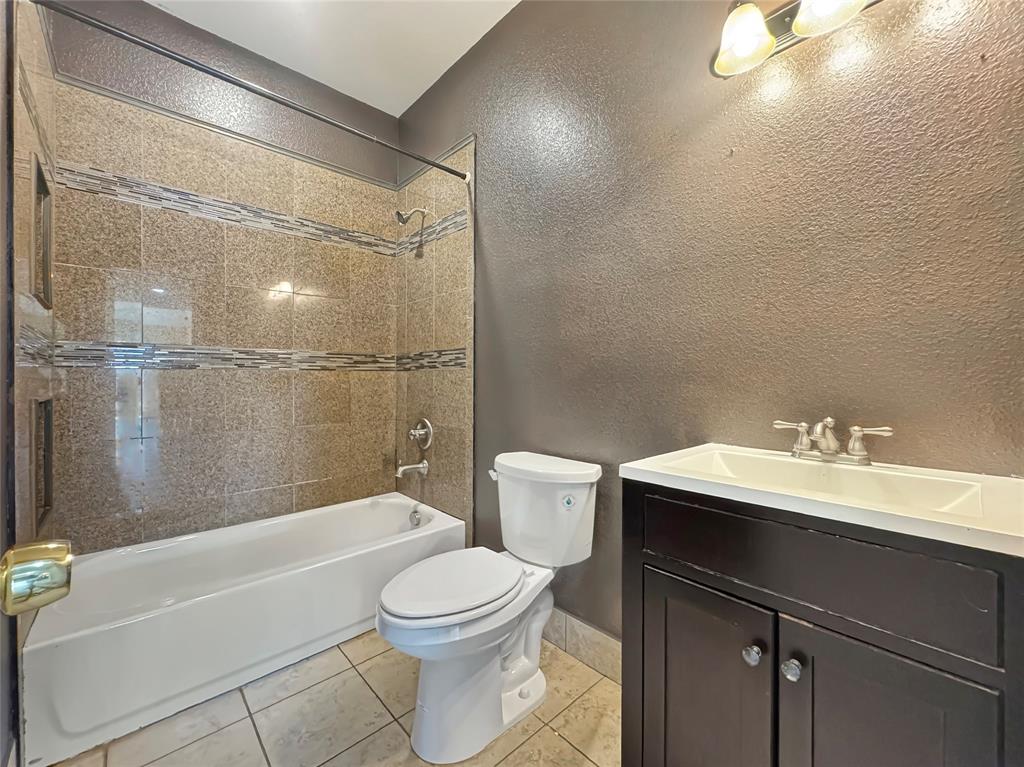 151 Crump Circle Red Oak, TX 75154 - Photo 14 of 21 Full bathroom featuring light tile patterned floors, vanity, bathtub / shower combination, and a textured wall