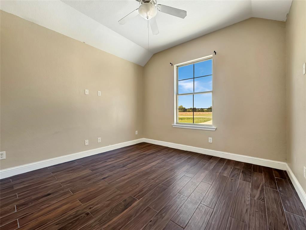 151 Crump Circle Red Oak, TX 75154 - Photo 19 of 21 Spare room featuring lofted ceiling, dark wood-style floors, and a ceiling fan