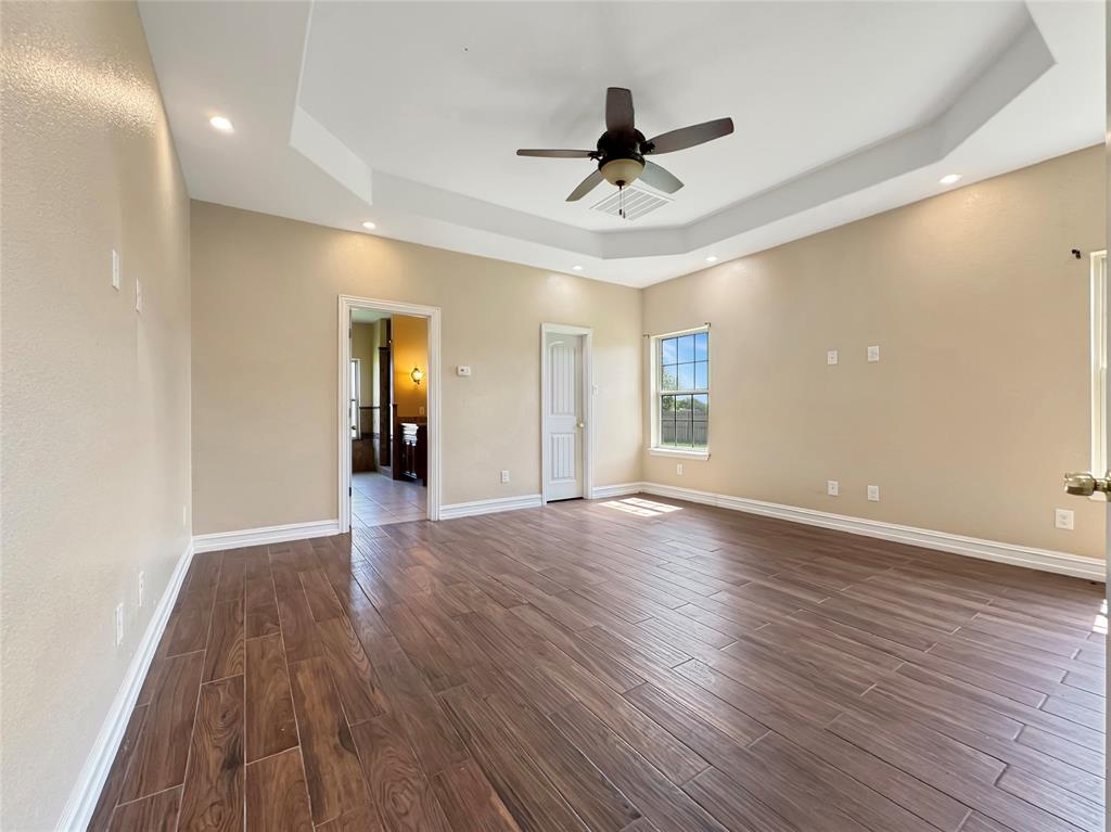 151 Crump Circle Red Oak, TX 75154 - Photo 21 of 21 Unfurnished room featuring dark wood-style flooring, a tray ceiling, a ceiling fan, and recessed lighting