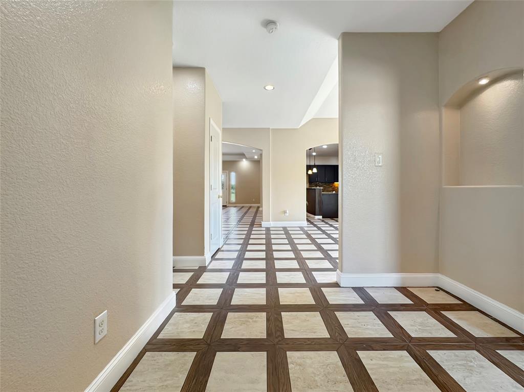 151 Crump Circle Red Oak, TX 75154 - Photo 5 of 21 Hallway featuring a textured wall, arched walkways, inlaid floor details, and recessed lighting