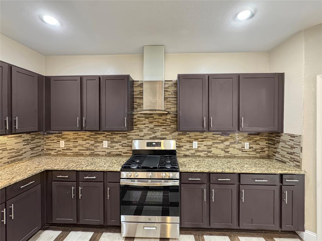 151 Crump Circle Red Oak, TX 75154 - Photo 7 of 21 Kitchen with stainless steel gas range oven, wall chimney exhaust hood, backsplash, light stone countertops, and recessed lighting