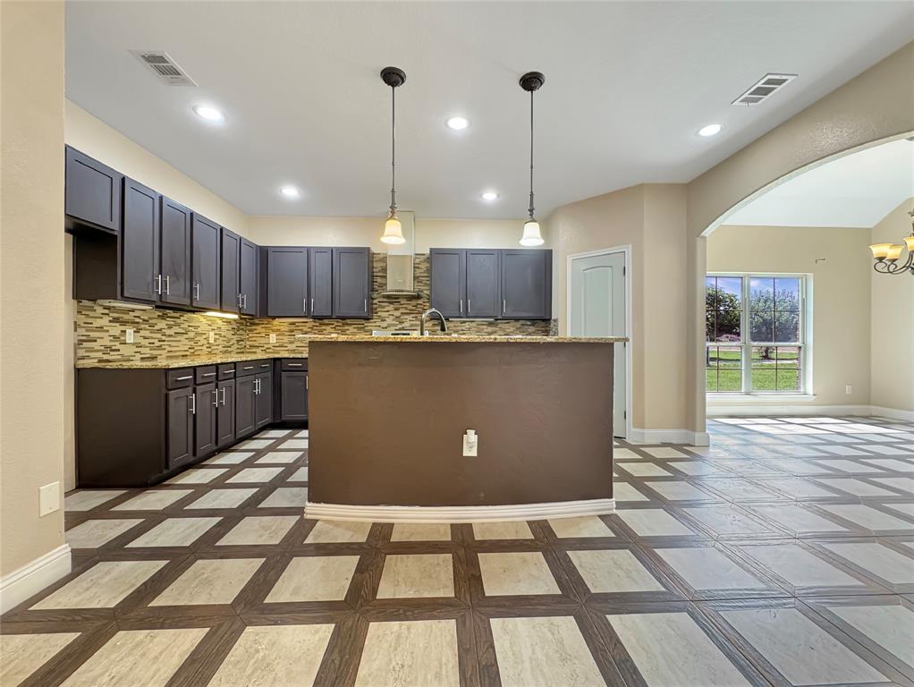151 Crump Circle Red Oak, TX 75154 - Photo 8 of 21 Kitchen with hanging light fixtures, inlaid floor details, arched walkways, backsplash, and recessed lighting