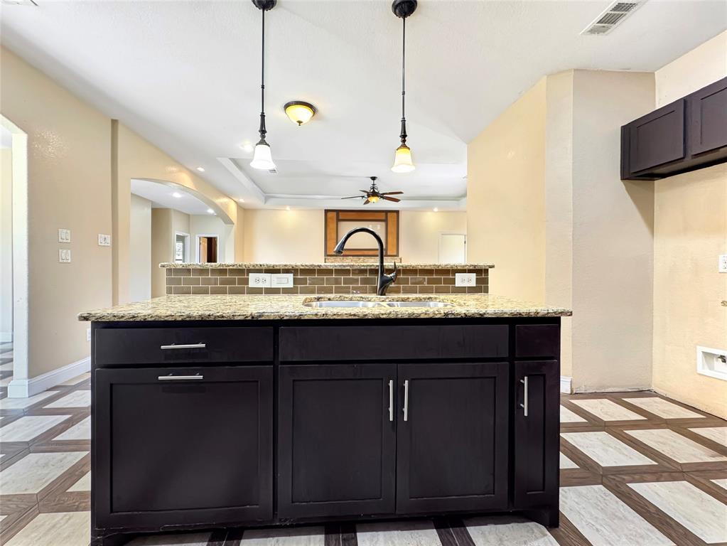 151 Crump Circle Red Oak, TX 75154 - Photo 9 of 21 Kitchen featuring dark cabinets, inlaid floor details, decorative backsplash, light stone countertops, and recessed lighting