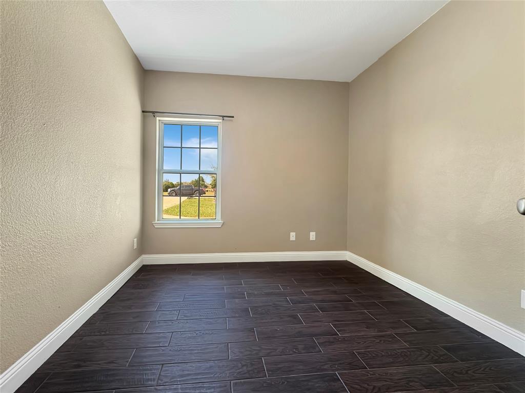 151 Crump Circle Red Oak, TX 75154 - Photo 10 of 21 Empty room with a textured wall and wood tiled floors