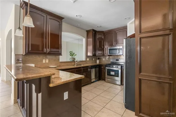 a kitchen with stainless steel appliances granite countertop a stove a sink and a microwave