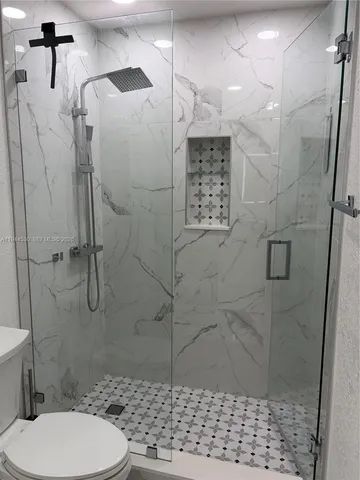 a bathroom with a toilet and a shower