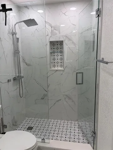 a bathroom with a shower a toilet and a shower