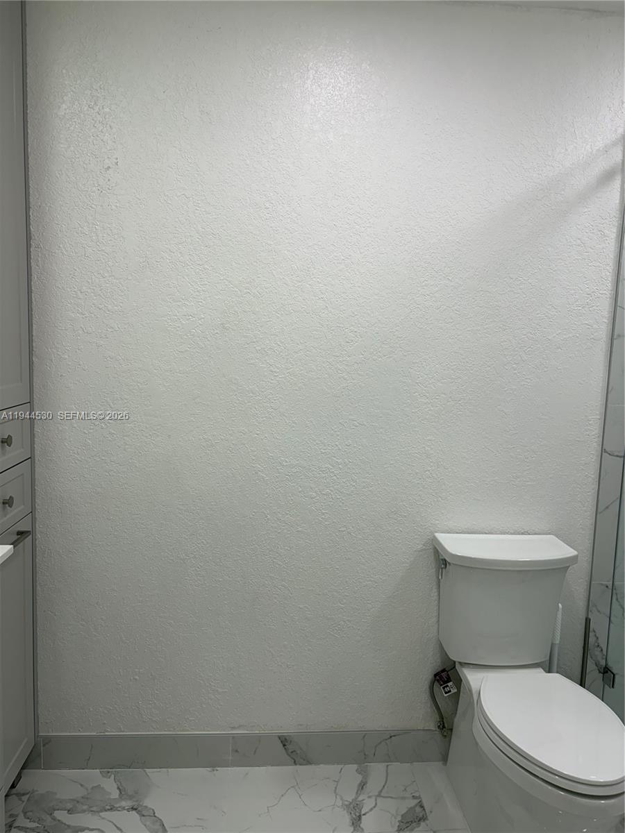 11956 Southwest 209th Street Miami, FL 33177 - Photo 13 of 14 a white toilet sitting next to a white wall