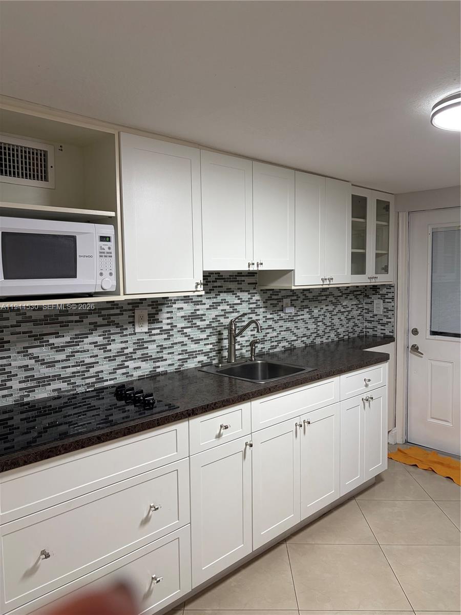 11956 Southwest 209th Street Miami, FL 33177 - Photo 6 of 14 a kitchen with granite countertop white cabinets and sink
