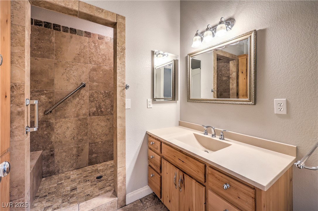 3910 West Pebble Road Las Vegas, NV 89139 - Photo 33 of 59 Guest house Full bathroom with vanity, walk in shower, a textured wall, and light tile patterned flooring