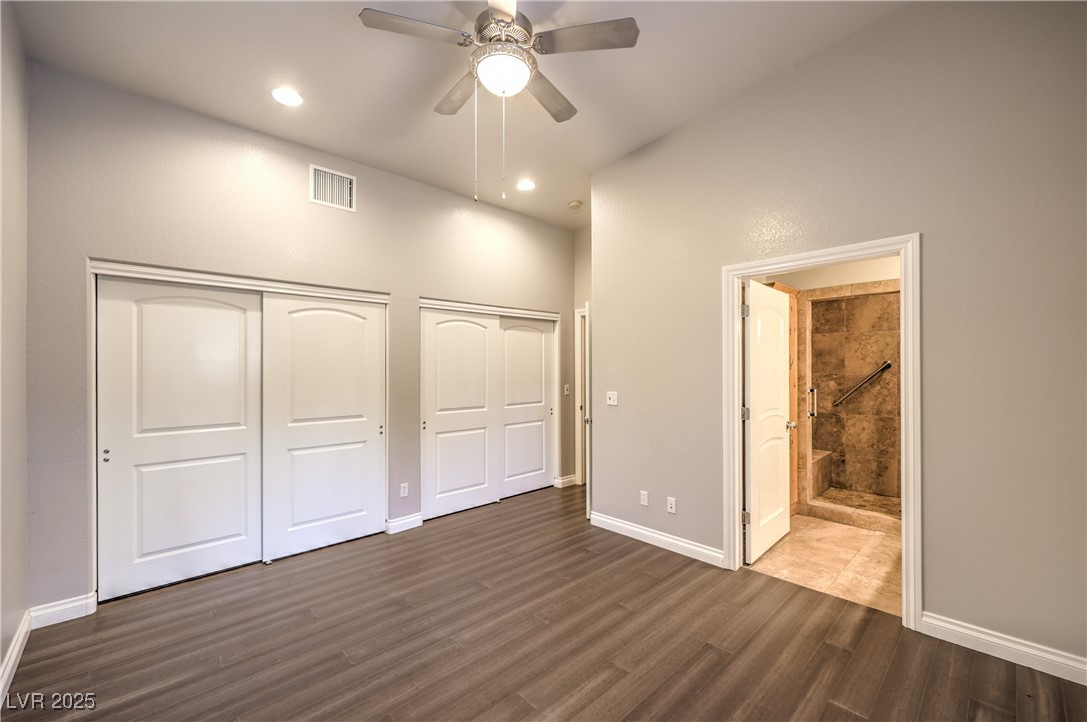 3910 West Pebble Road Las Vegas, NV 89139 - Photo 39 of 59 Guest house bedroom featuring multiple closets, dark wood finished floors, ceiling fan, recessed lighting, and connected bathroom