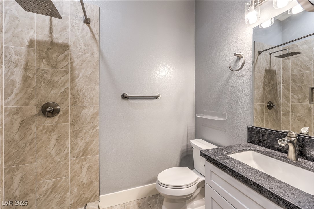 3910 West Pebble Road Las Vegas, NV 89139 - Photo 43 of 59 Guest house Full bathroom with a textured wall, vanity, and a tile shower