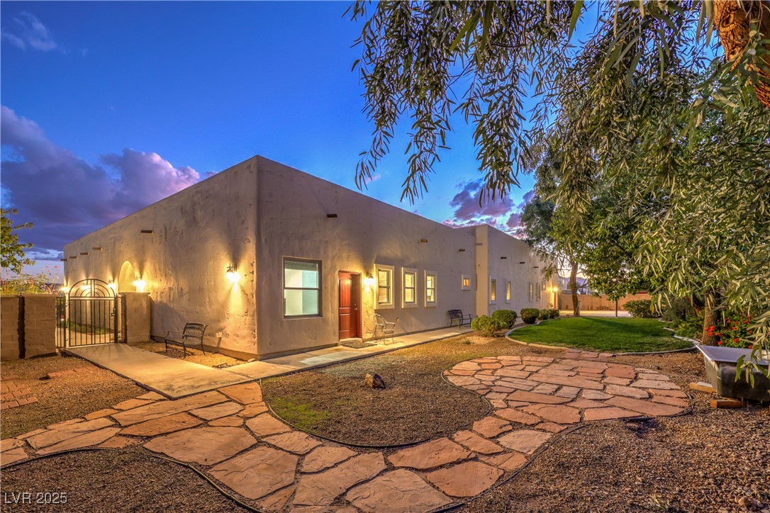 3910 West Pebble Road Las Vegas, NV 89139 - Photo 47 of 59 Back of house at dusk featuring a patio area, grass & basketball court