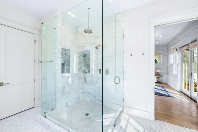 a bathroom with double vanity sinks a large mirror and a bathtub