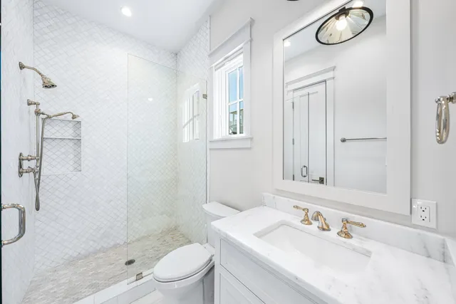 a bathroom with a sink a toilet and shower